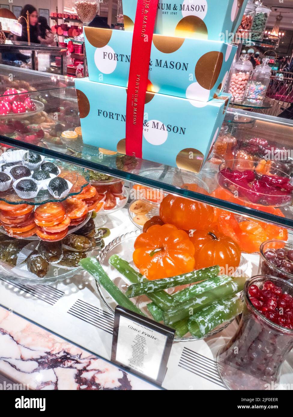 Fortnum & Mason Food Hall with luxury display of hand made glacé fruits selection, Angelica, Kiwi slices , Black figs, Lemon slices, Peach halves, etc Stock Photo