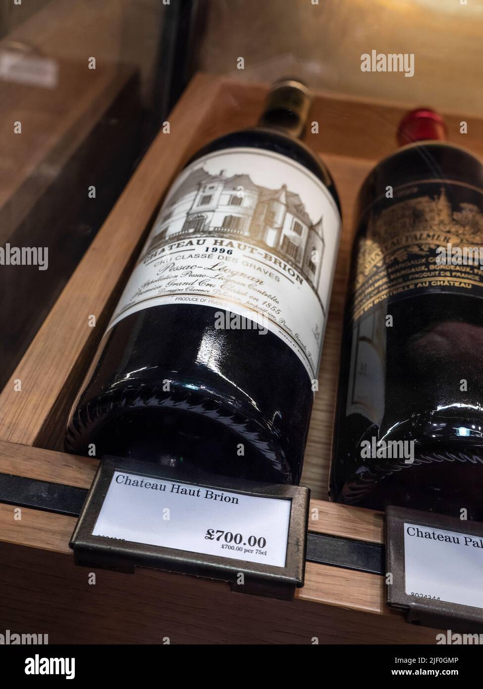 Chateau Haut Brion bottle and price label.  Fortnum & Mason Food & Drinks Hall interior with luxury wine cabinet display of Bordeaux wine bottle Chateau Haut Brion 1996 on sale priced at £700 Fortnum & Mason Food & Drinks Hall store Piccadilly St. James's, London W1A 1ER Stock Photo