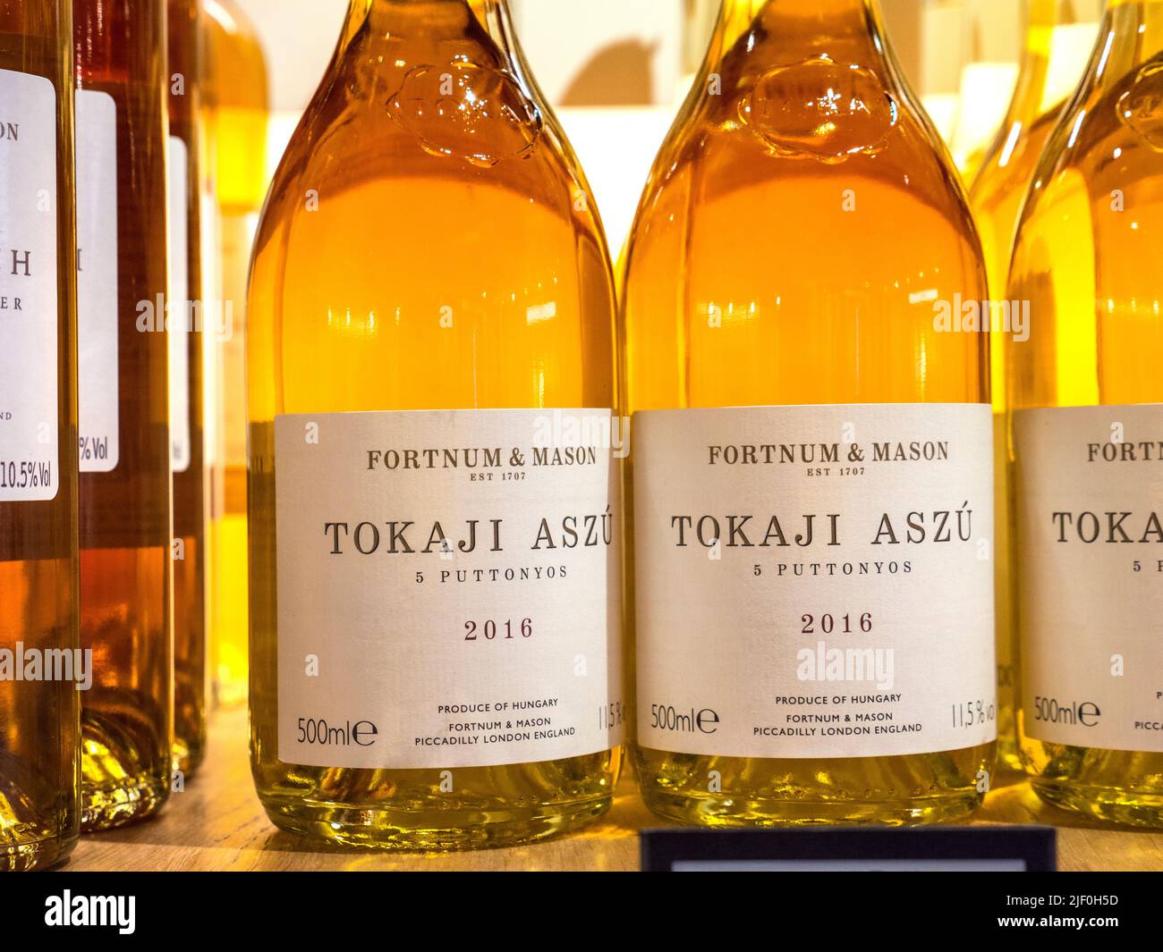 TOKAJI ASZU Fortnum & Mason branded Tokaji Aszú Hungarian off dry sweet white wine 2016 on display for sale at Fortnum & Mason Food Hall Wine Department. It is produced by Pajzos Tokaj, one of the great producers of the region. It is made by blending hand-picked shrivelled berries with top quality base wines. 5 puttonyos denotes the sweetness. Traditionally paired with blue cheese, pate and dessert. Fortnum & Mason Food Hall Wine Department, Piccadilly St. James's, London W1A 1ER Stock Photo