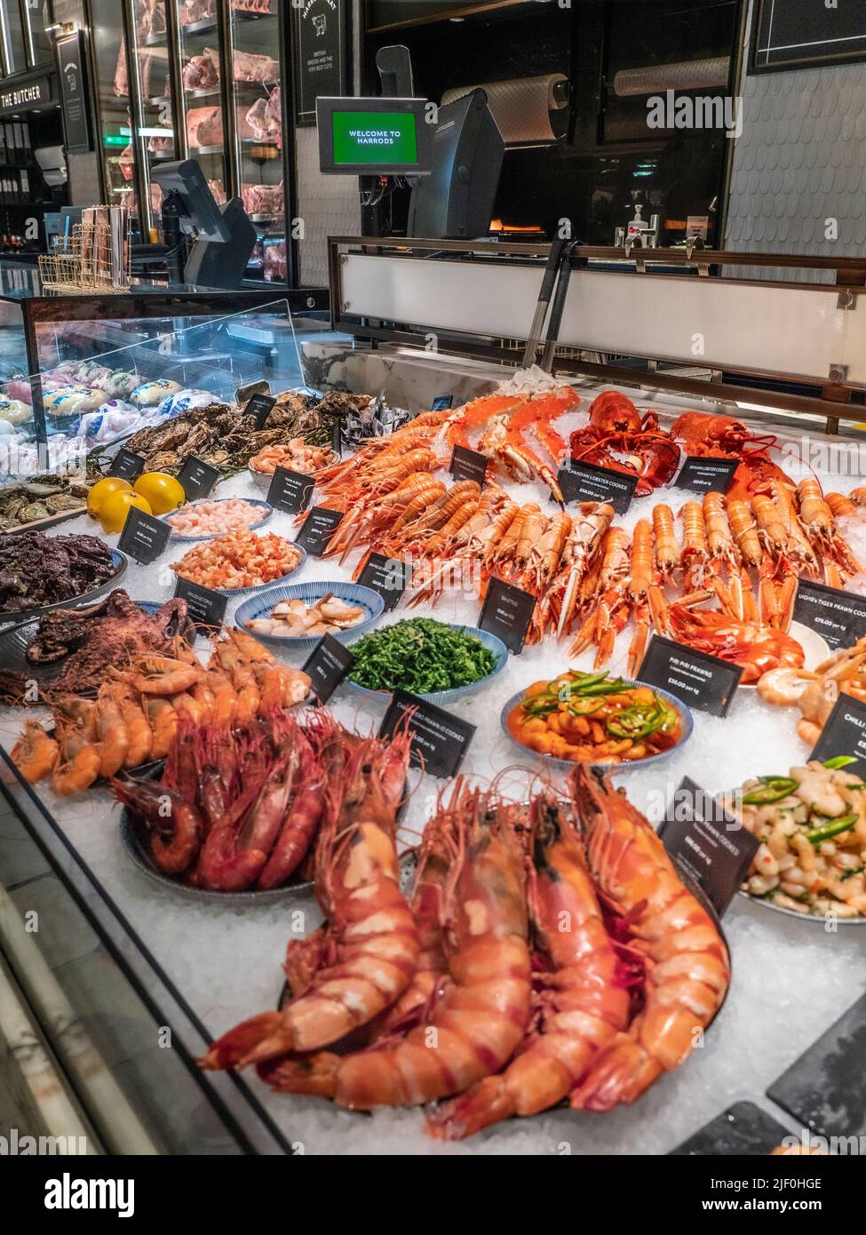 Harrods Food Hall FRESH FISH interior featuring 'The Fishmonger' with a wide variety of exclusive hand picked Brixham UK fish seafood crustacea on display in crushed ice for sale, Harrods Food Hall Fishmonger department Store Mall Shop,  Brompton Rd, Knightsbridge, London SW1X 7XL Stock Photo