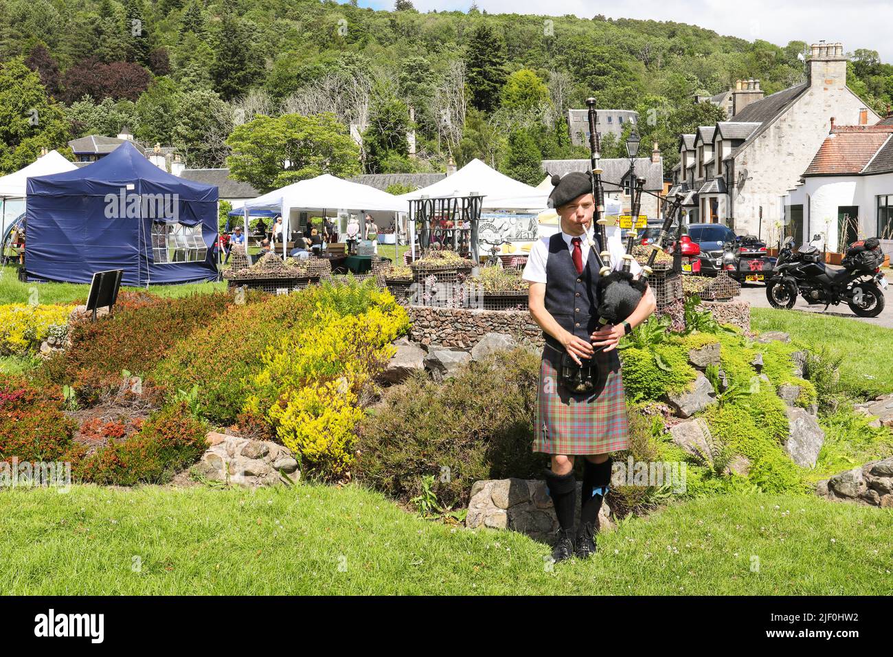 Young man playing the bagpipes at Drumnadrochit craft fair and market near Loch Ness, Scotland, UK Stock Photo