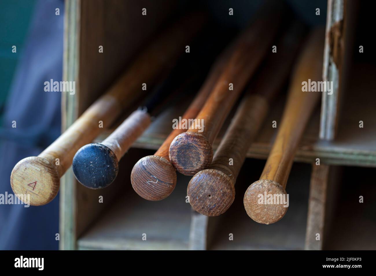 Old wood baseball bats in a bat storage rack at a baseball park Stock Photo