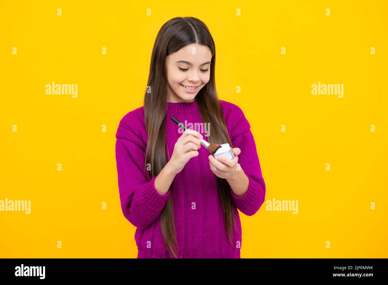 Child girl 12, 13, 14 years old making beauty make up with powder and brush. Beautiful teenager