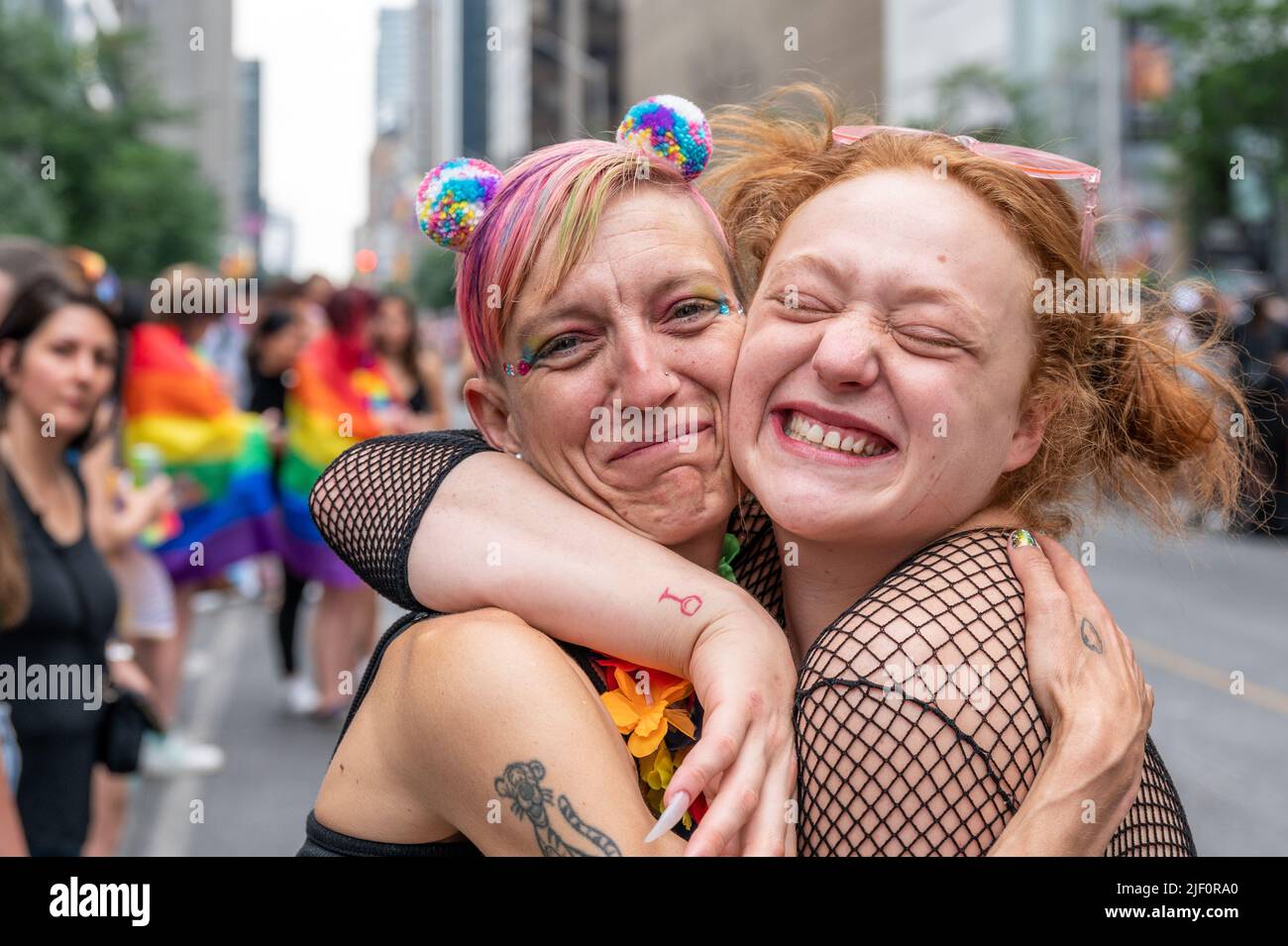 Emotional hug between two female people during the Pride Parade in Bloor Street. Stock Photo