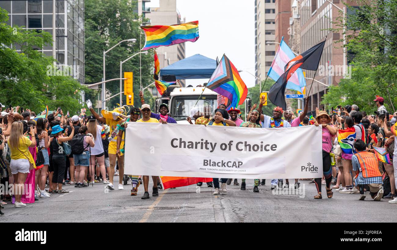 A group of people marching behind a banner reading Charity of Choice BlackCAP . The partake in the Pride Parade in Bloor Street. Stock Photo