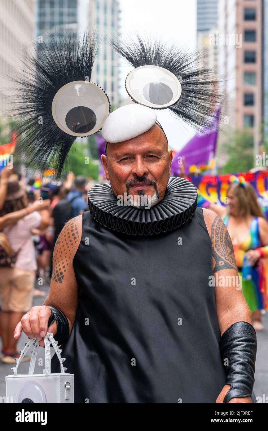 Medium shot of a man wearing black  clothes and a white purse while marching in Bloor Street during Pride Parade Stock Photo