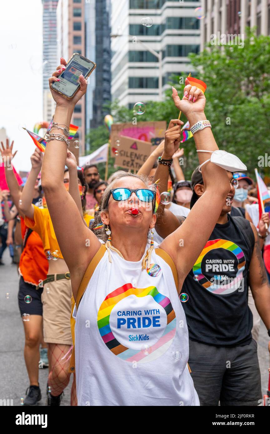 Group of people representing Sick Kids Hospital marching in Bloor Street during Pride Parade Stock Photo