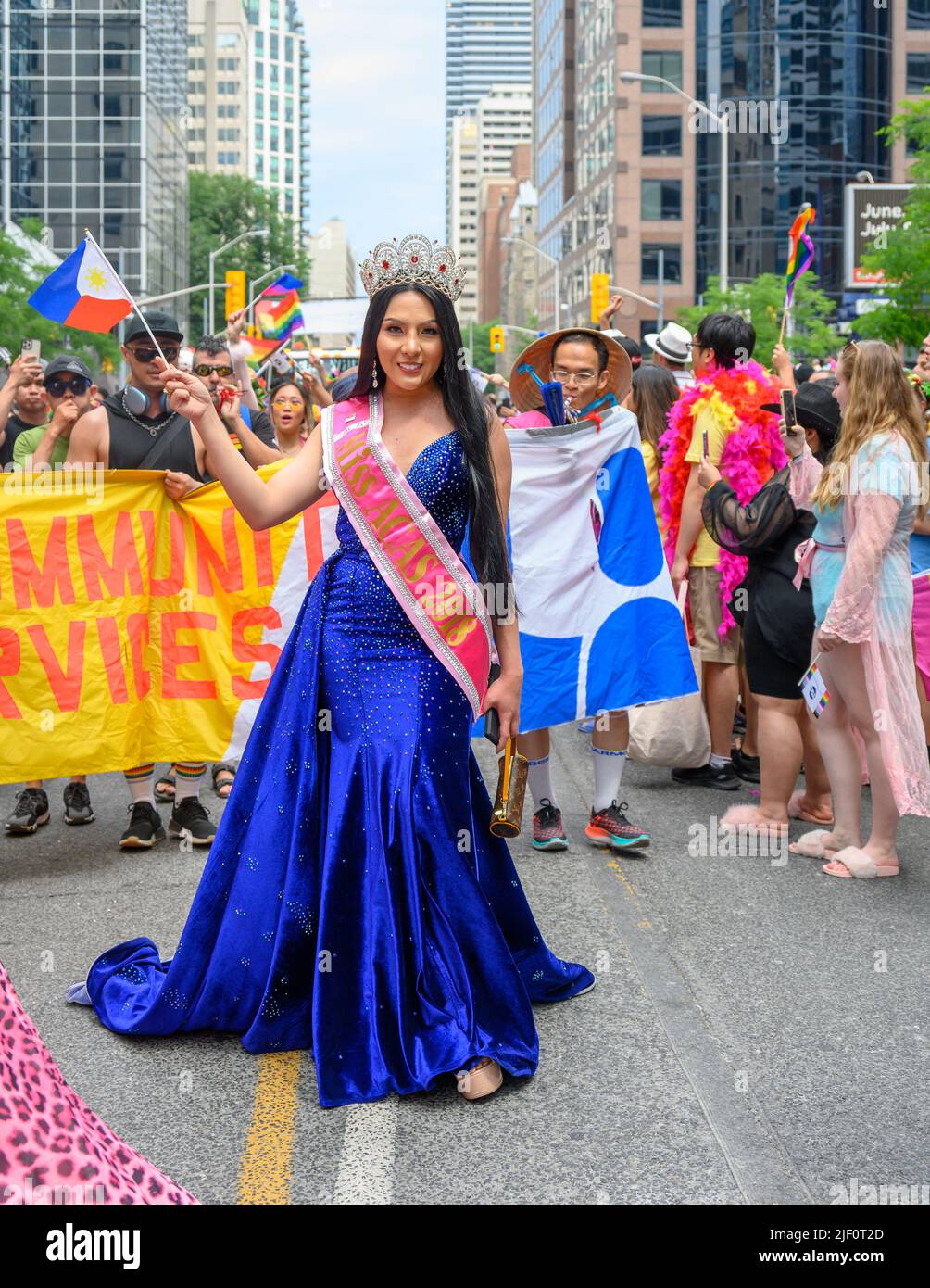 A woman in a blue dress and with a sign reading Miss Acas 2018 marches in Pride Parade. Stock Photo