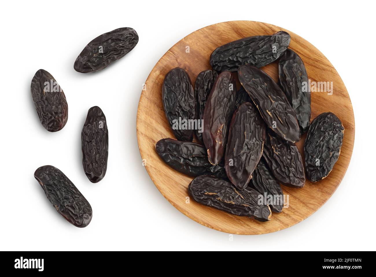 Tonka bean in wooden bowl isolated on white background with full depth