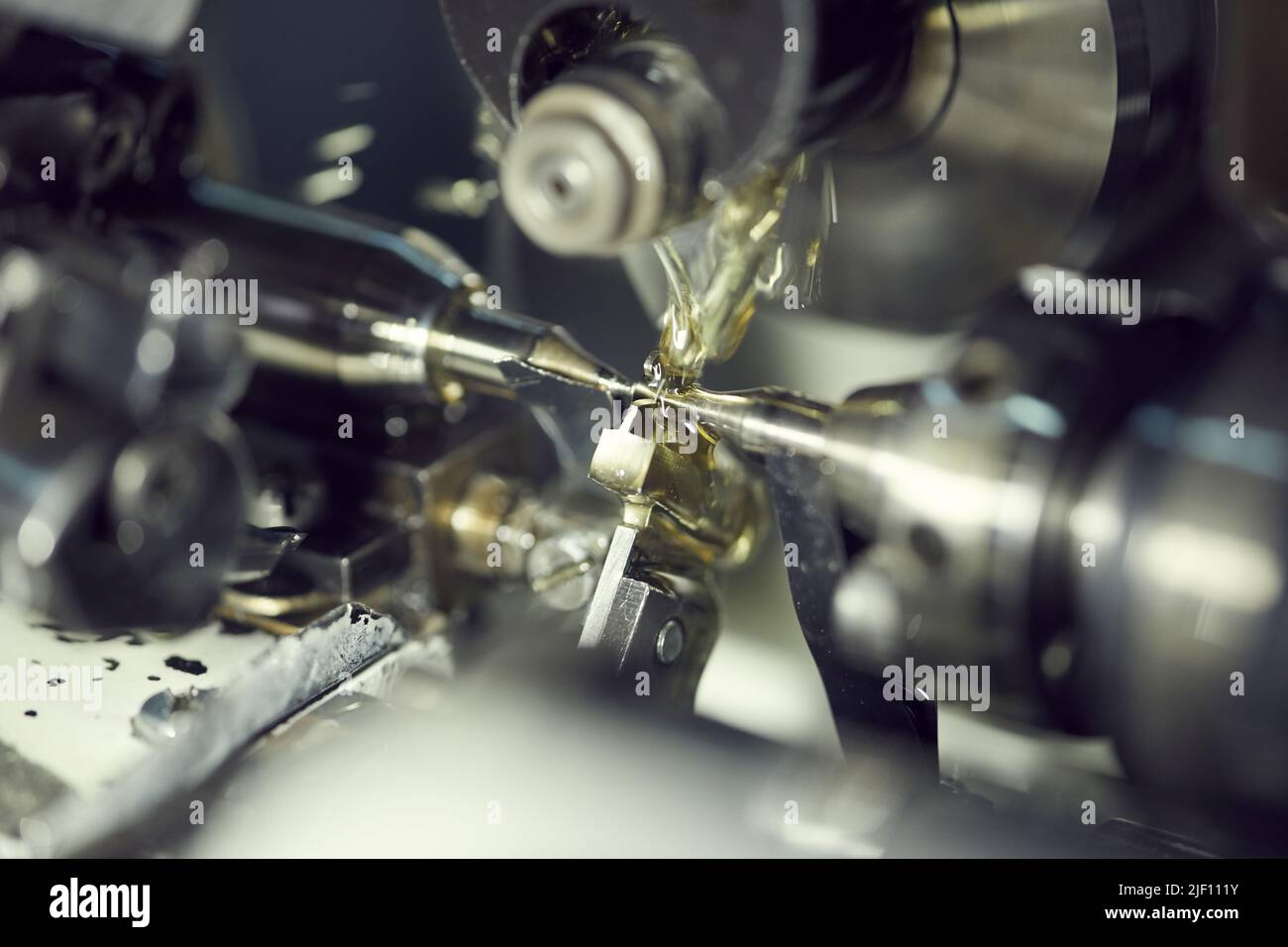 Closeup of processing metal part using fluid on modern lathe with coolant lubricant system