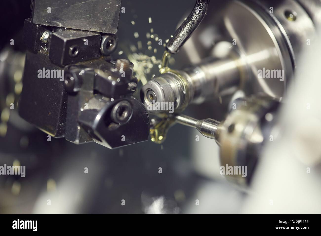 Closeup of cutting fluid pouring on drill tool of lathe machine during