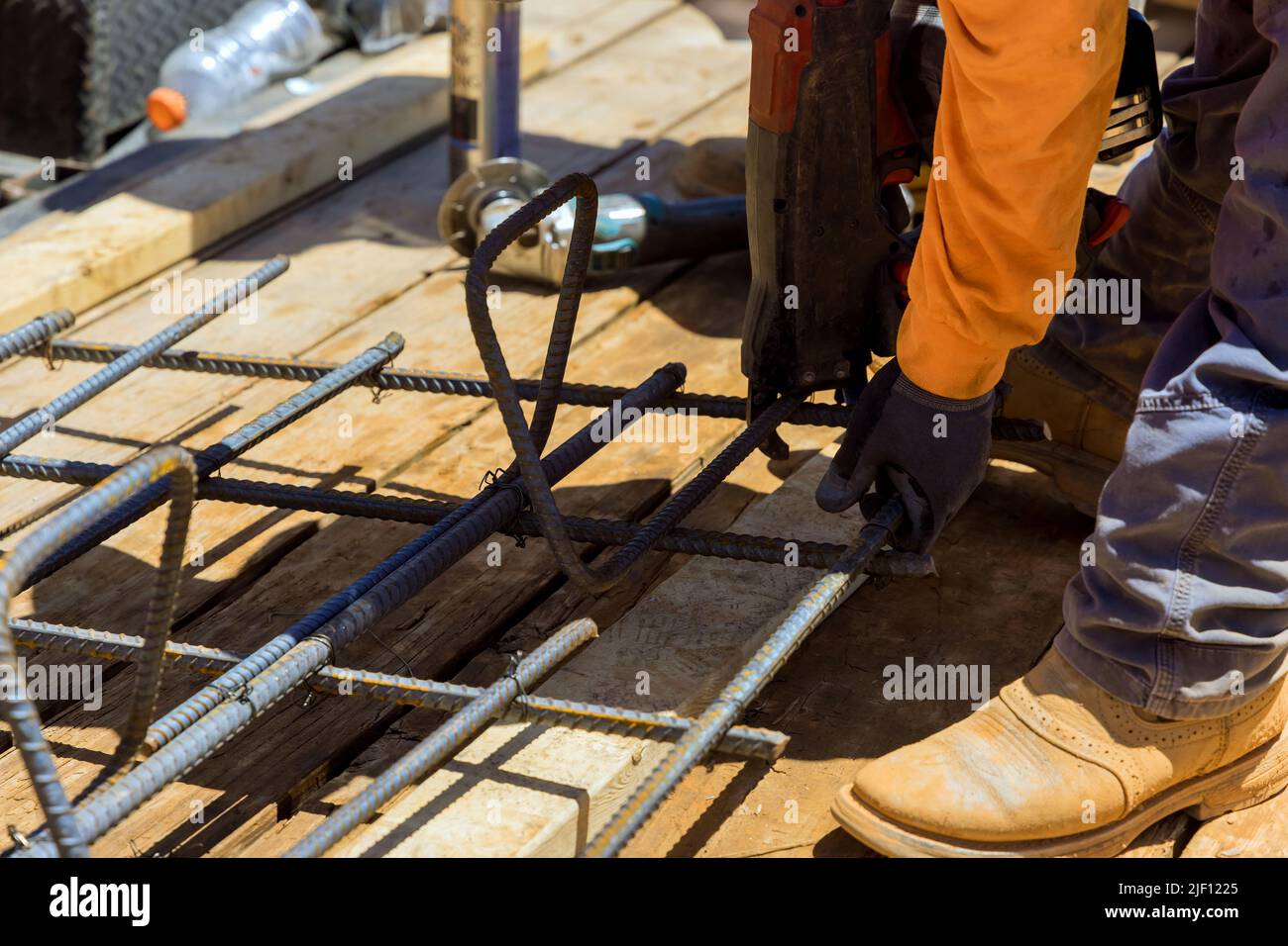 Rebar tying tool used by construction worker to secure steel bars with