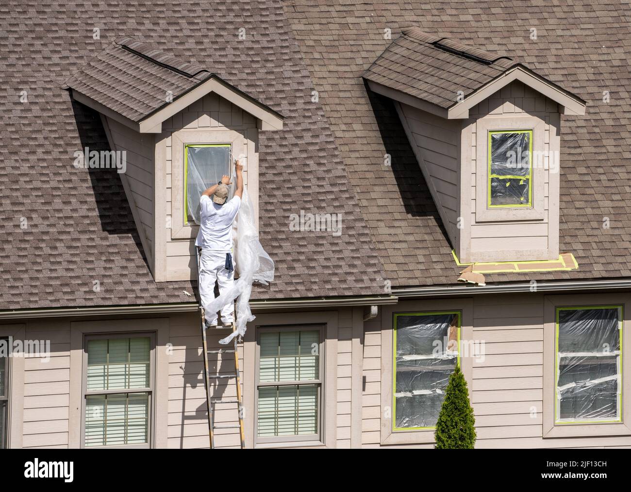 Masking tape holding plastic covering in place on windows prior to