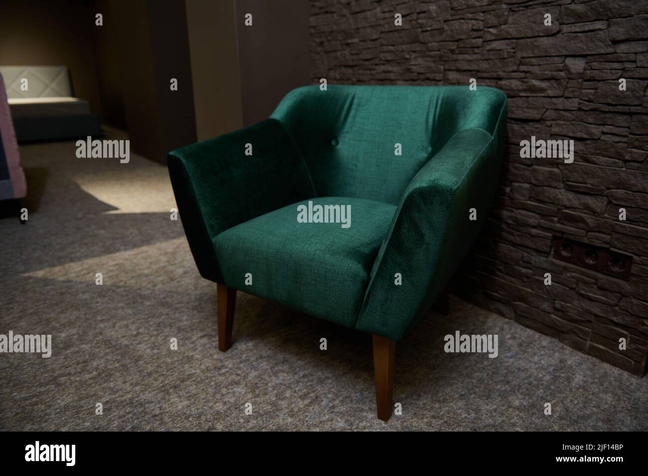 The green velour sofa with pillows in the bright attic room has an  artificial fireplace.A spacious living room with white walls and a  decorated Christ Stock Photo - Alamy