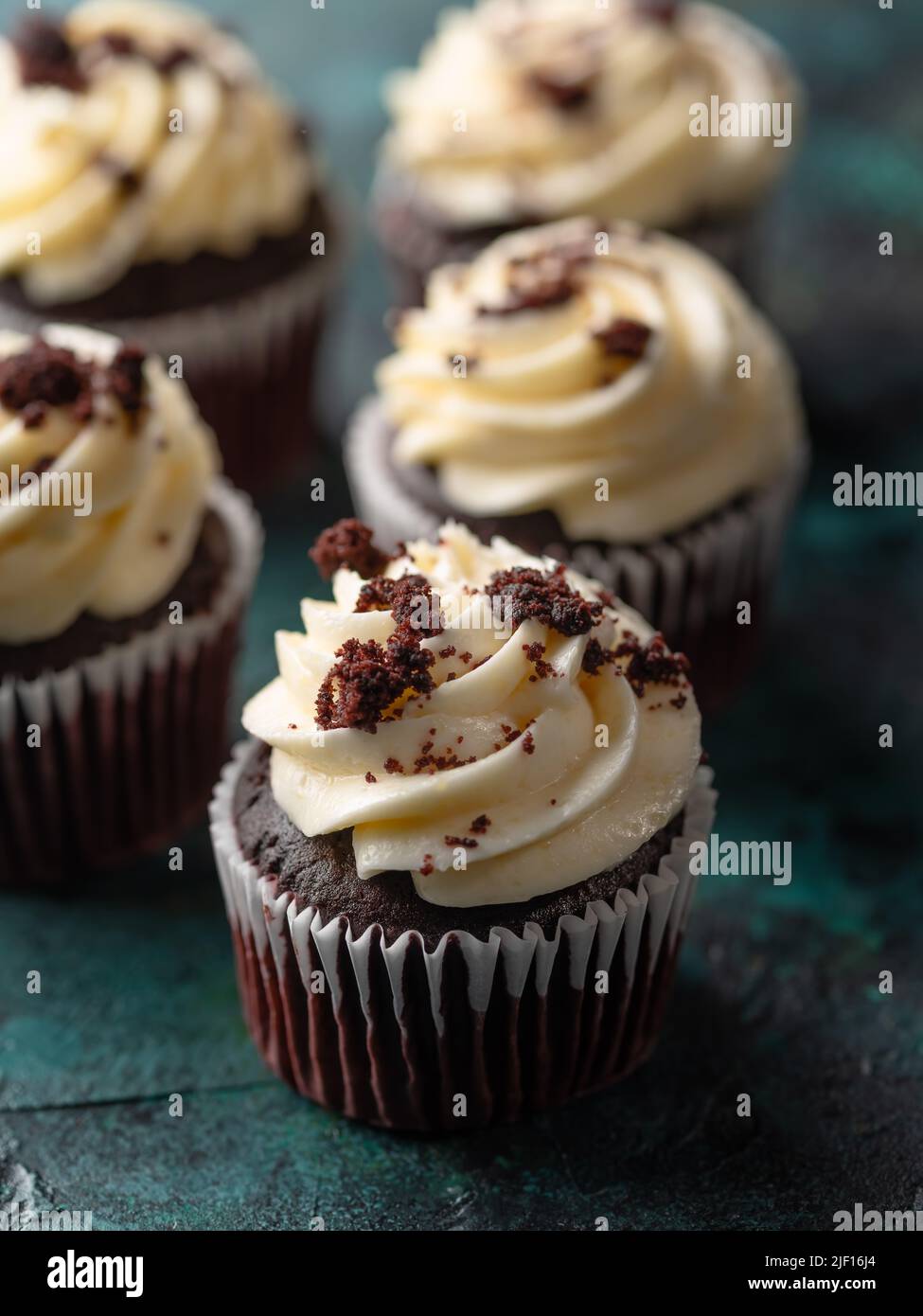 Close-up. Chocolate muffins with whipped cream, decorated with dark ...