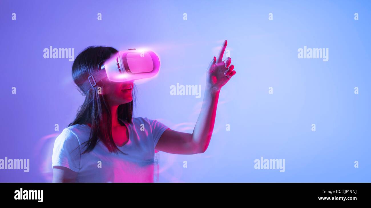 Excited woman playing video game in VR glasses Stock Photo