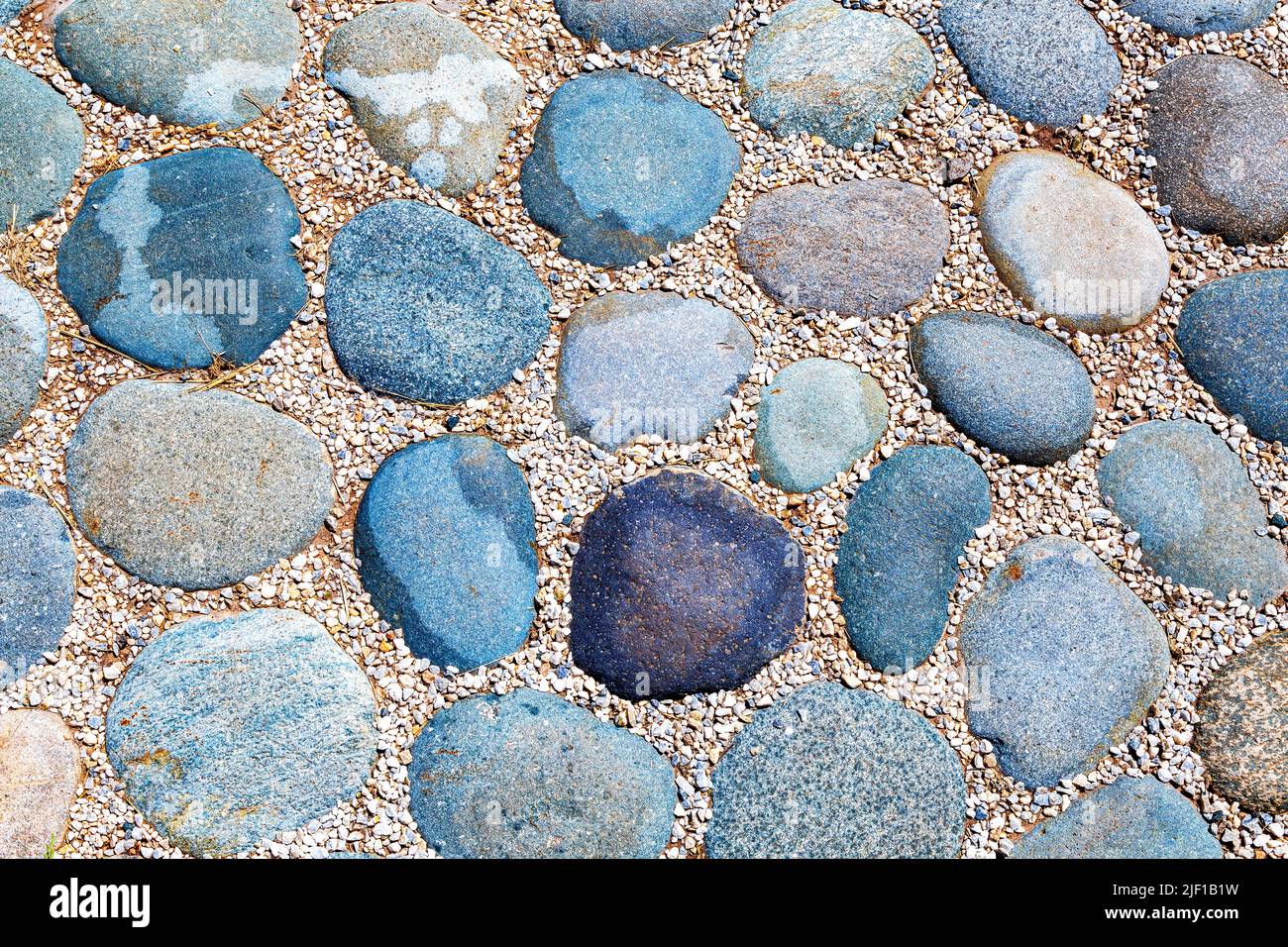 Cobblestone pavement on the road as creative background texture Stock Photo