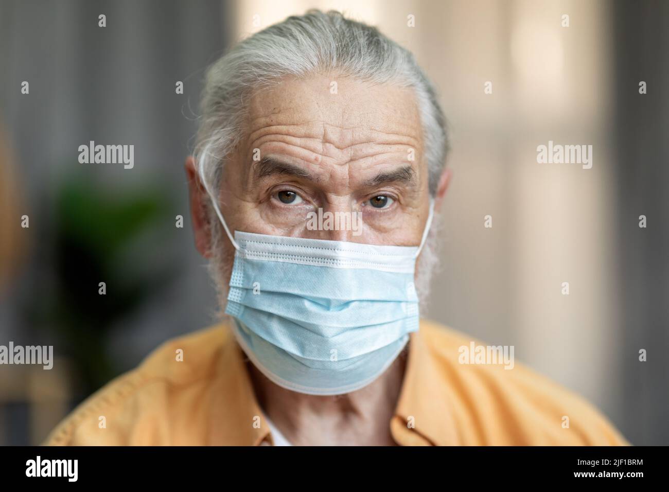Portrait of an old man wearing a medical mask Stock Photo