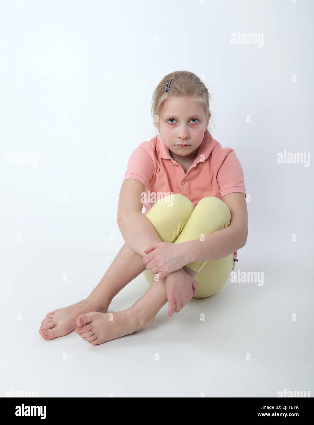young sad girl sitting on the floor Stock Photo