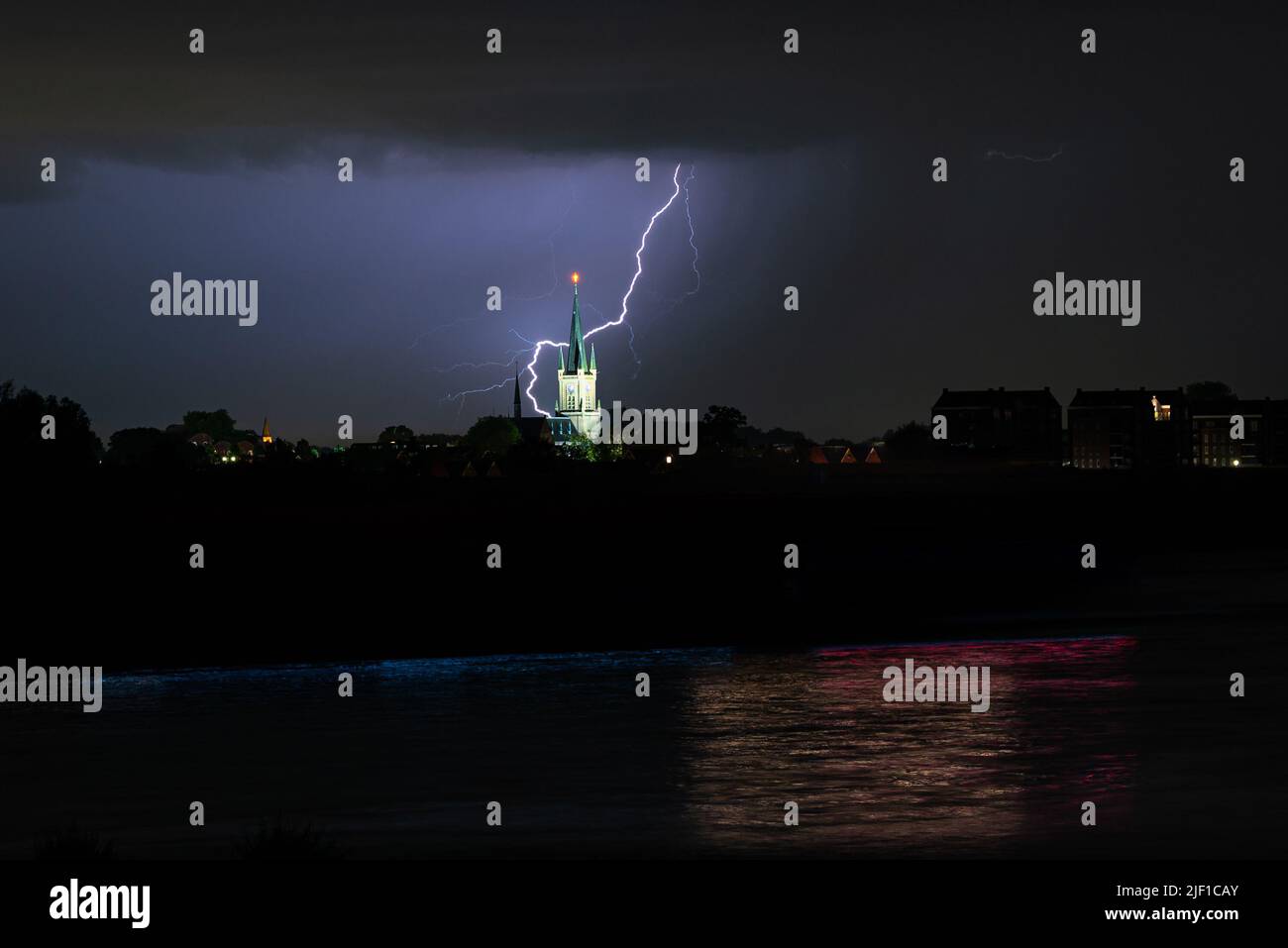 Lightning bolt strikes behind a church near a river Stock Photo Alamy