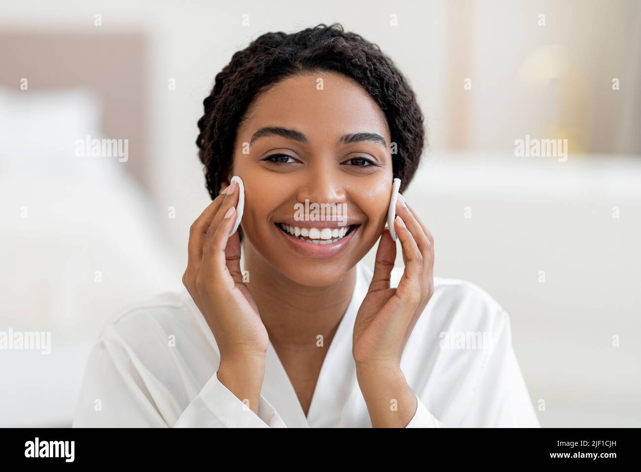 Skincare Concept. Cheerful Black Female Using Two Cotton Pads For Cleansing Skin Stock Photo