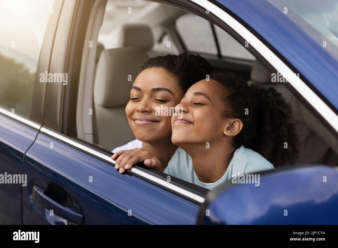 Happy African American Mom And Daughter Sitting In Car Stock Photo