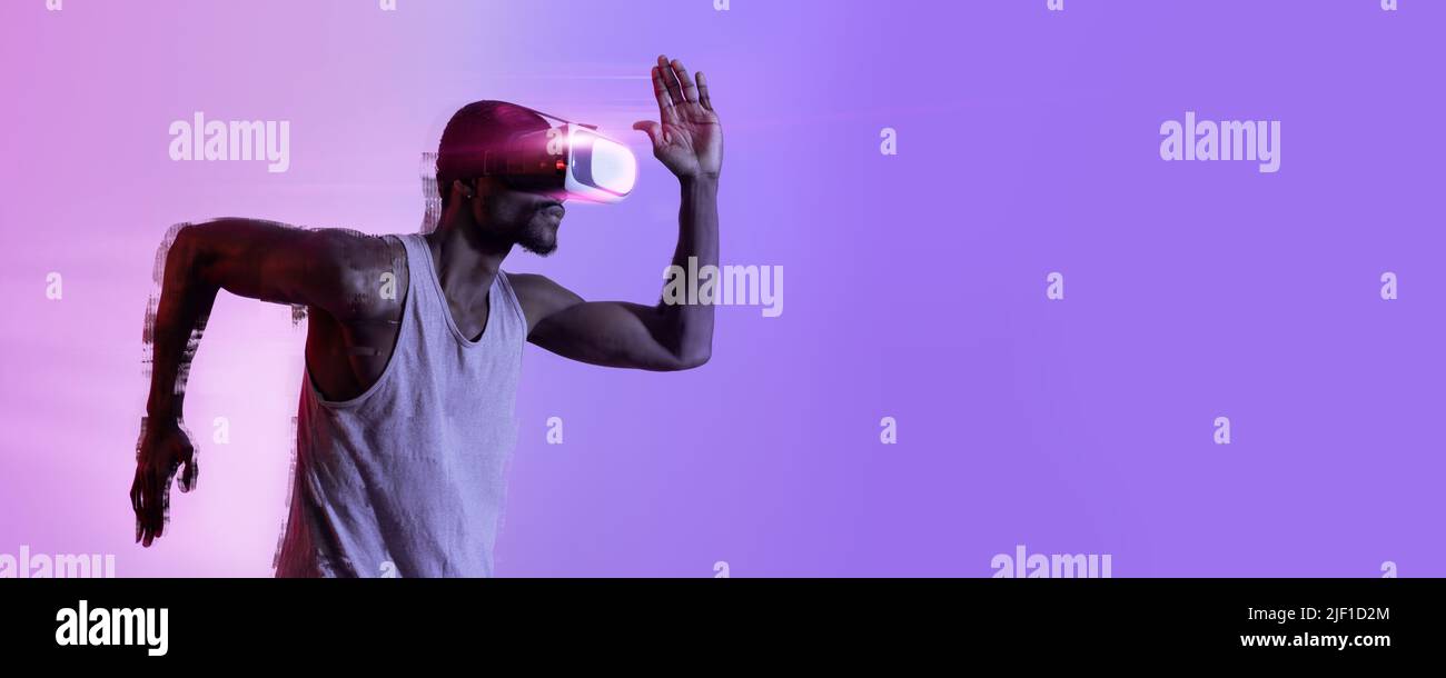 African american guy in VR headset running in neon light Stock Photo