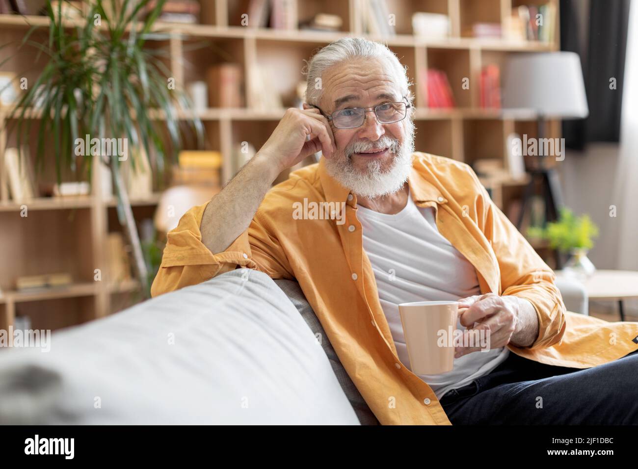 Relaxed elderly man enjoying morning coffee at home Stock Photo