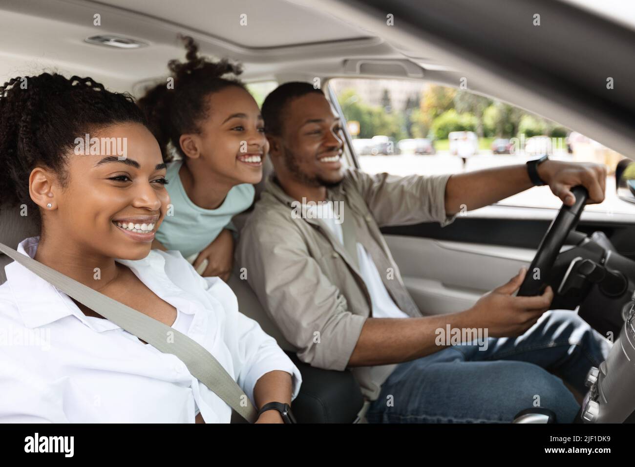 Cheerful Family Driving A Car Having Road Trip, Side View Stock Photo