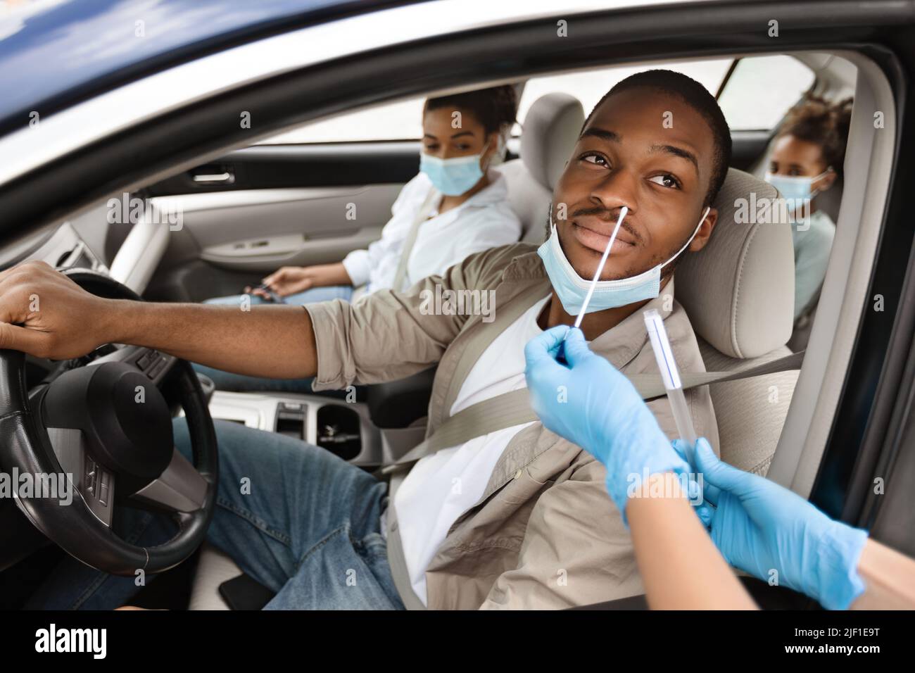 African American Man Getting Tested For Coronavirus In Car Stock Photo