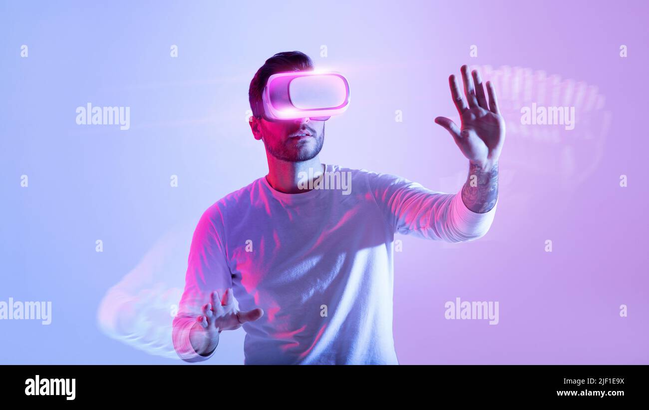 Man Having Virtual Reality Experience In VR Glasses, Neon Light Stock Photo