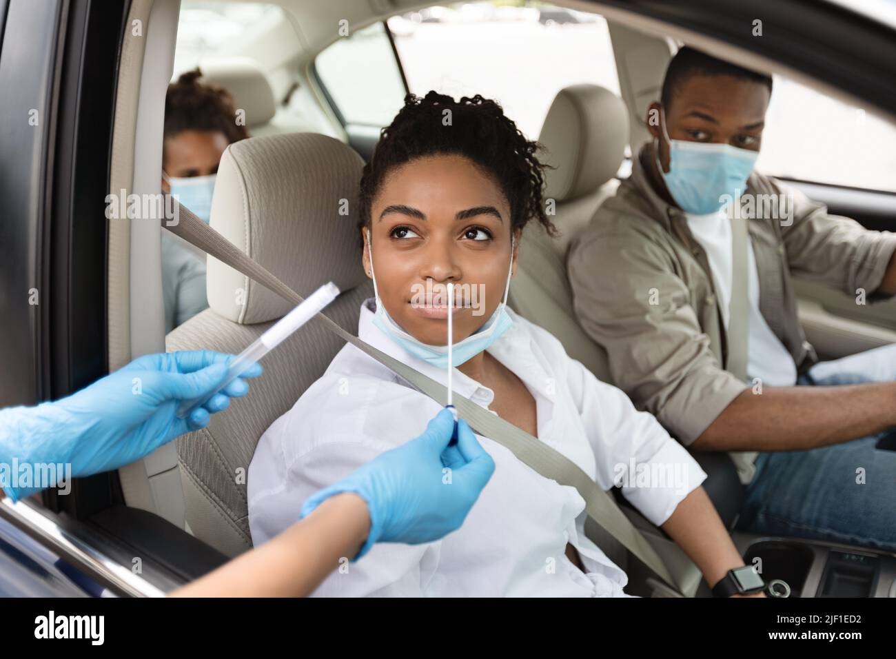 Black Family Of Three Getting Tested For Coronavirus In Automobile Stock Photo