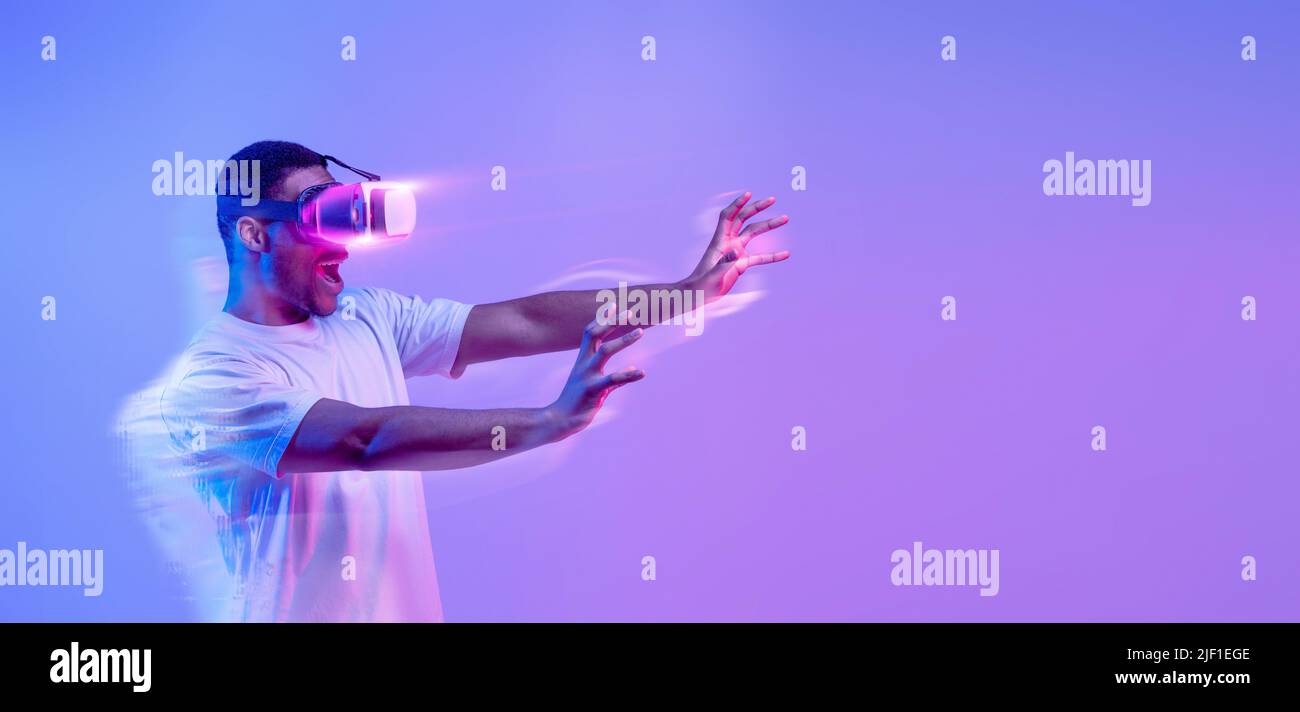 Amazed black man in VR headset, panorama with copy space Stock Photo