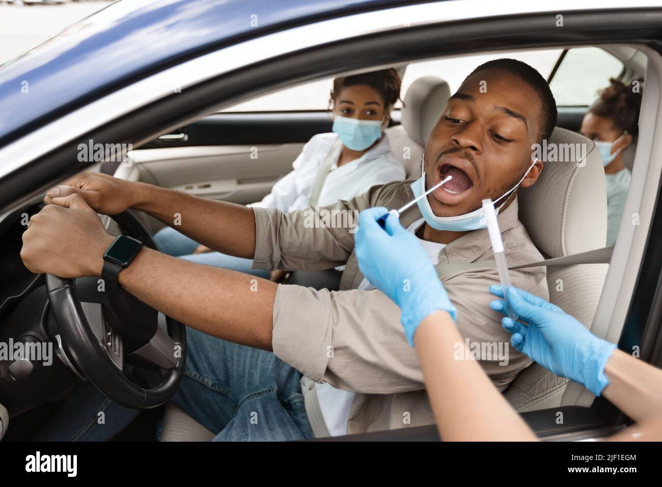 Black Male Driver Getting Tested For Covid-19 Sitting In Automobile Stock Photo