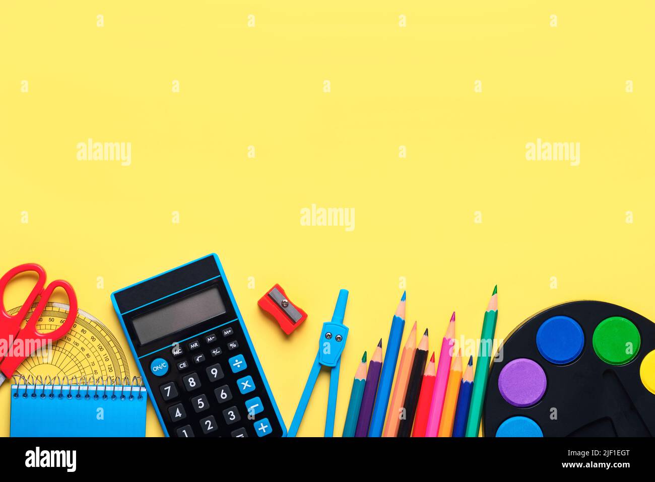 Top view of school supplies with space for text on yellow background. Back to school concept Stock Photo