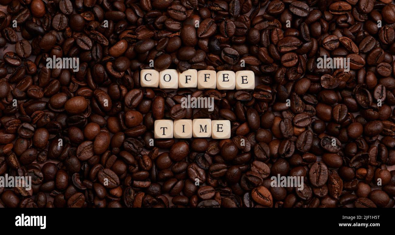 the word coffee time in the center of a lot of coffee beans Stock Photo
