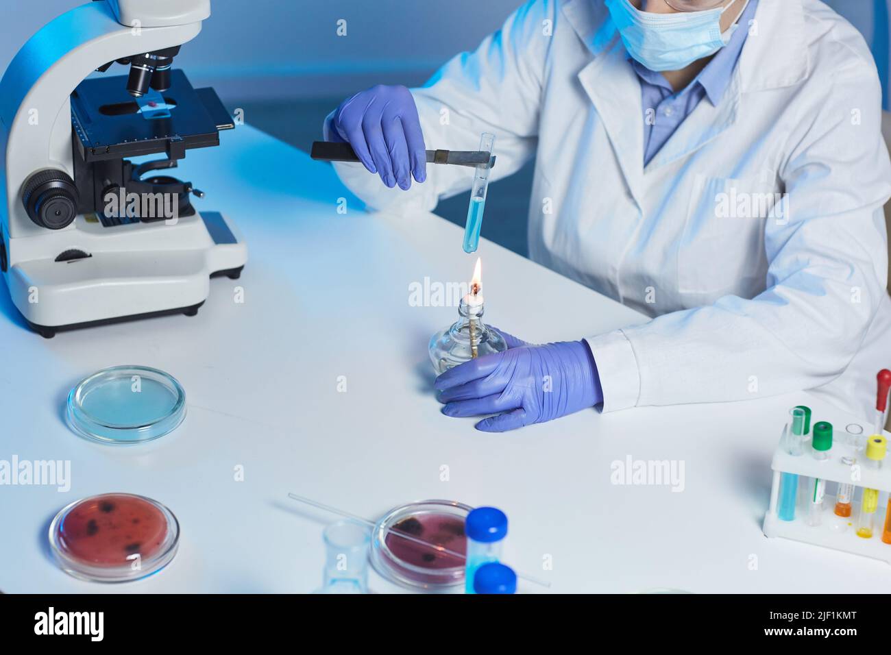 Lab Tech Face Less Close-up of unrecognizable lab technician in gloves and mask sitting at ...