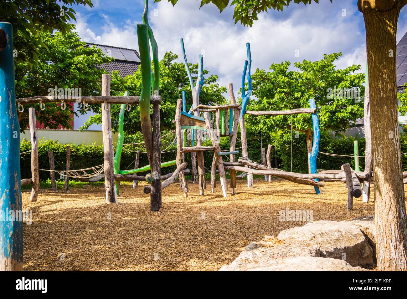 Empty public playground on sunny day with play equipments made from wood Stock Photo