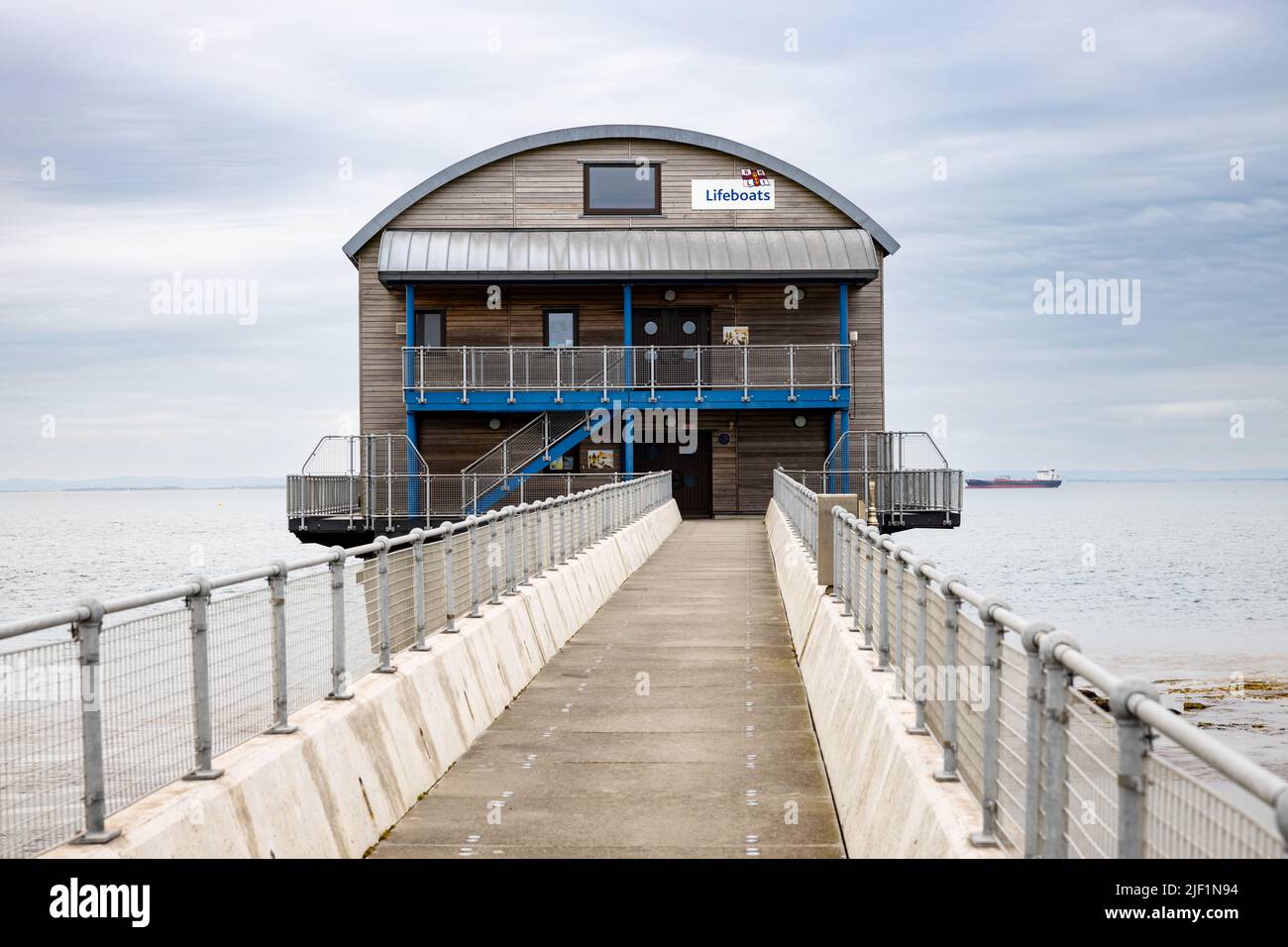 Front end view along a concrete bridge to the wooden clad Bembridge Royal National Lifeboat Institution RNLI Life Boat Station on the Isle of Wight Stock Photo