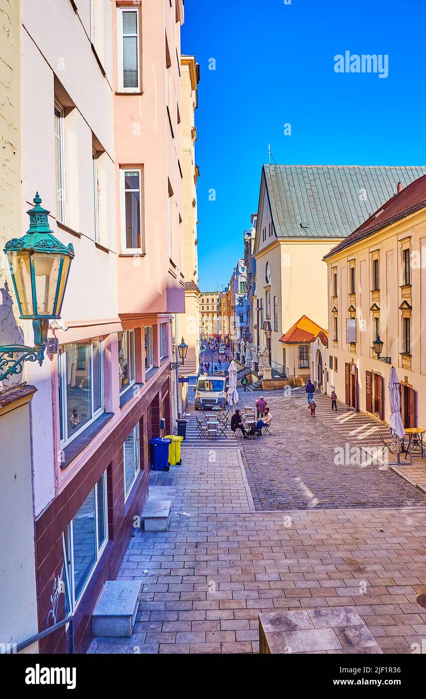 BRNO, CZECH REPUBLIC - MARCH 10, 2022: The narrow street in old town with outdoor cafes, on March 10 in Brno, Czech Republic Stock Photo