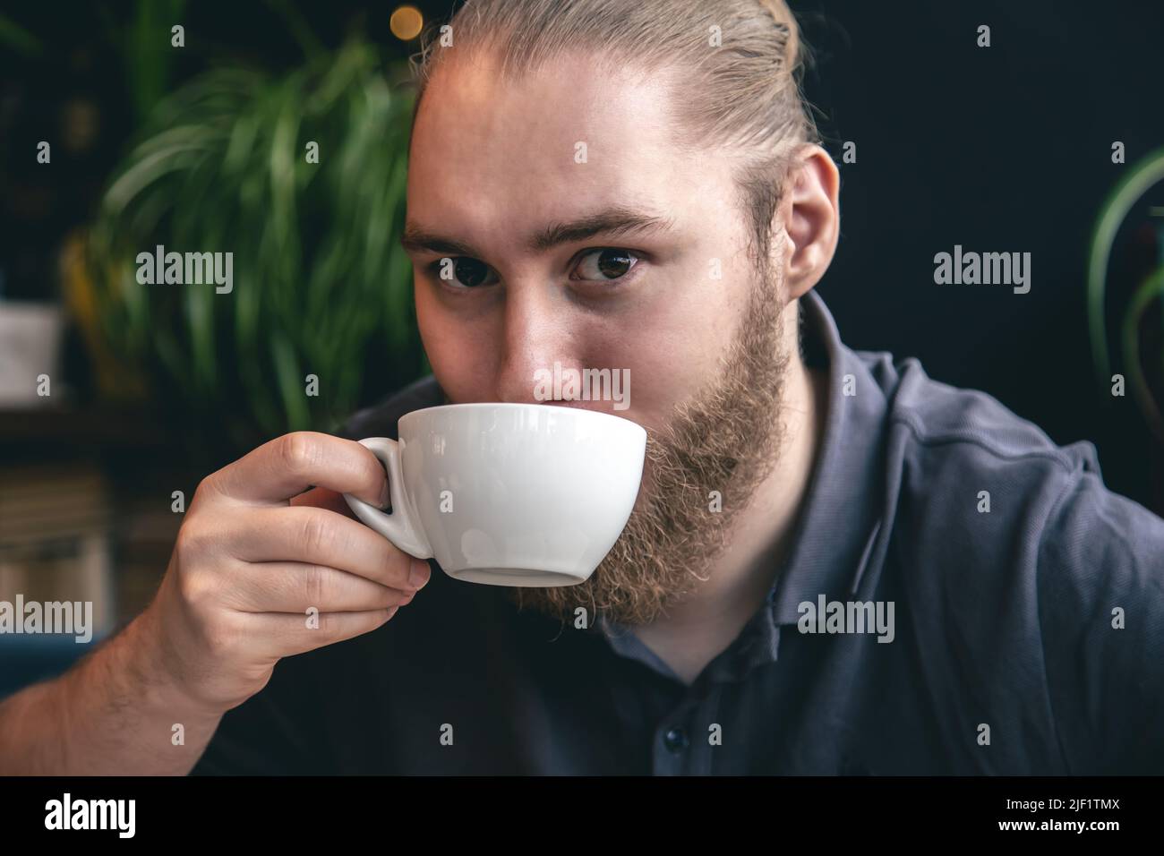 Portrait of a young bearded man with a cup of tea. Stock Photo