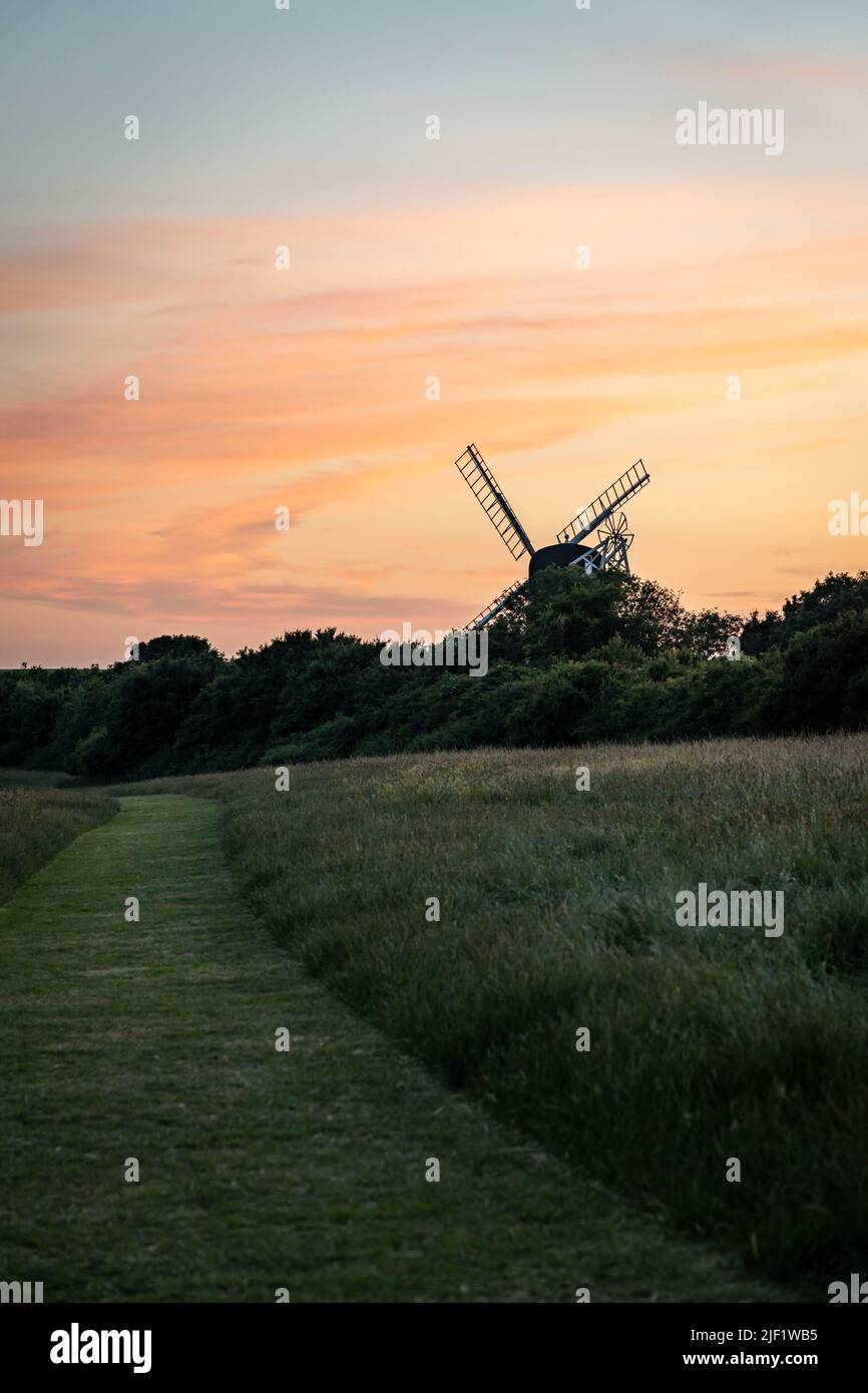 Field and windmill at dusk Stock Photo