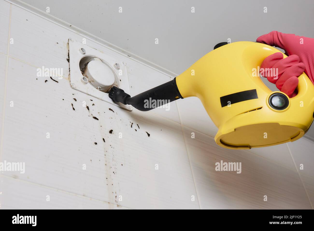 A man wipes dust from a ventilation grill technician cleaning air Stock