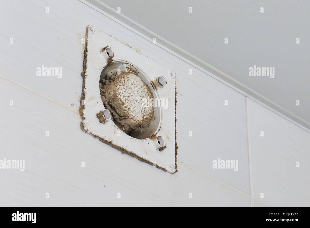 A man wipes dust from a ventilation grill technician cleaning air Stock