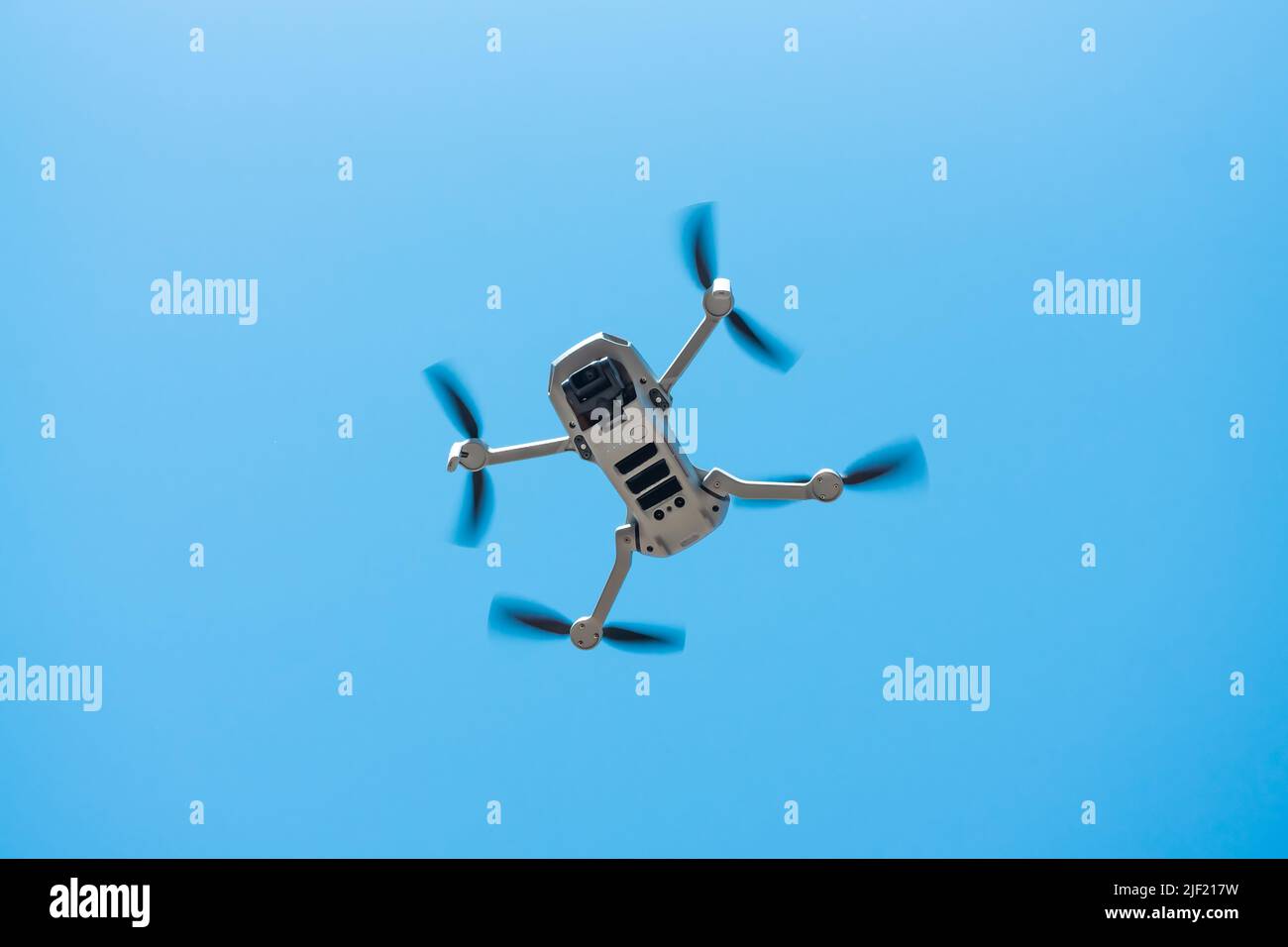 Consumer drone with camera hovering against sky Stock Photo