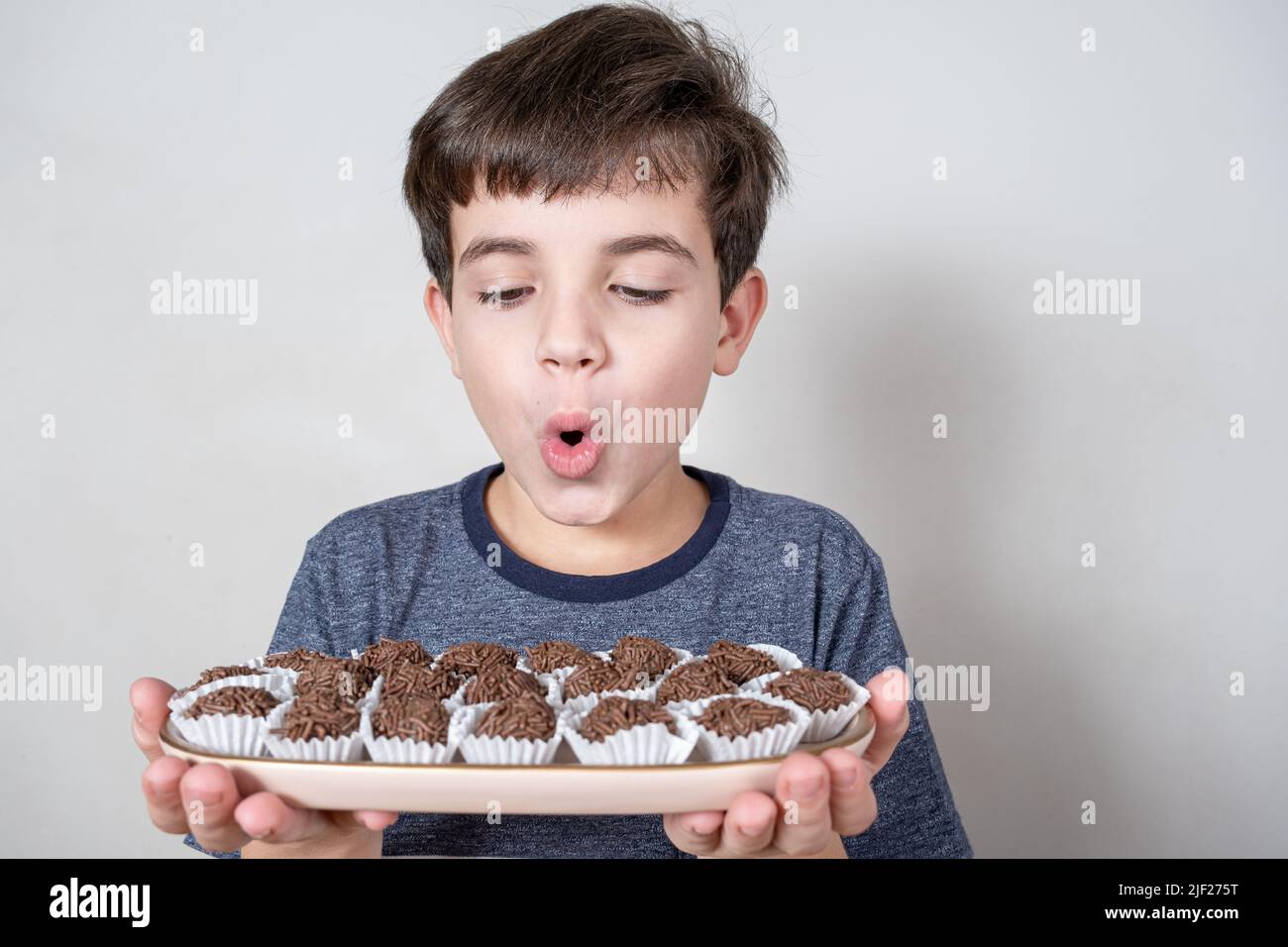 9 Year Old Brazilian Looking At A Tray With Several Brazilian Fudge Balls And Looking Surprised