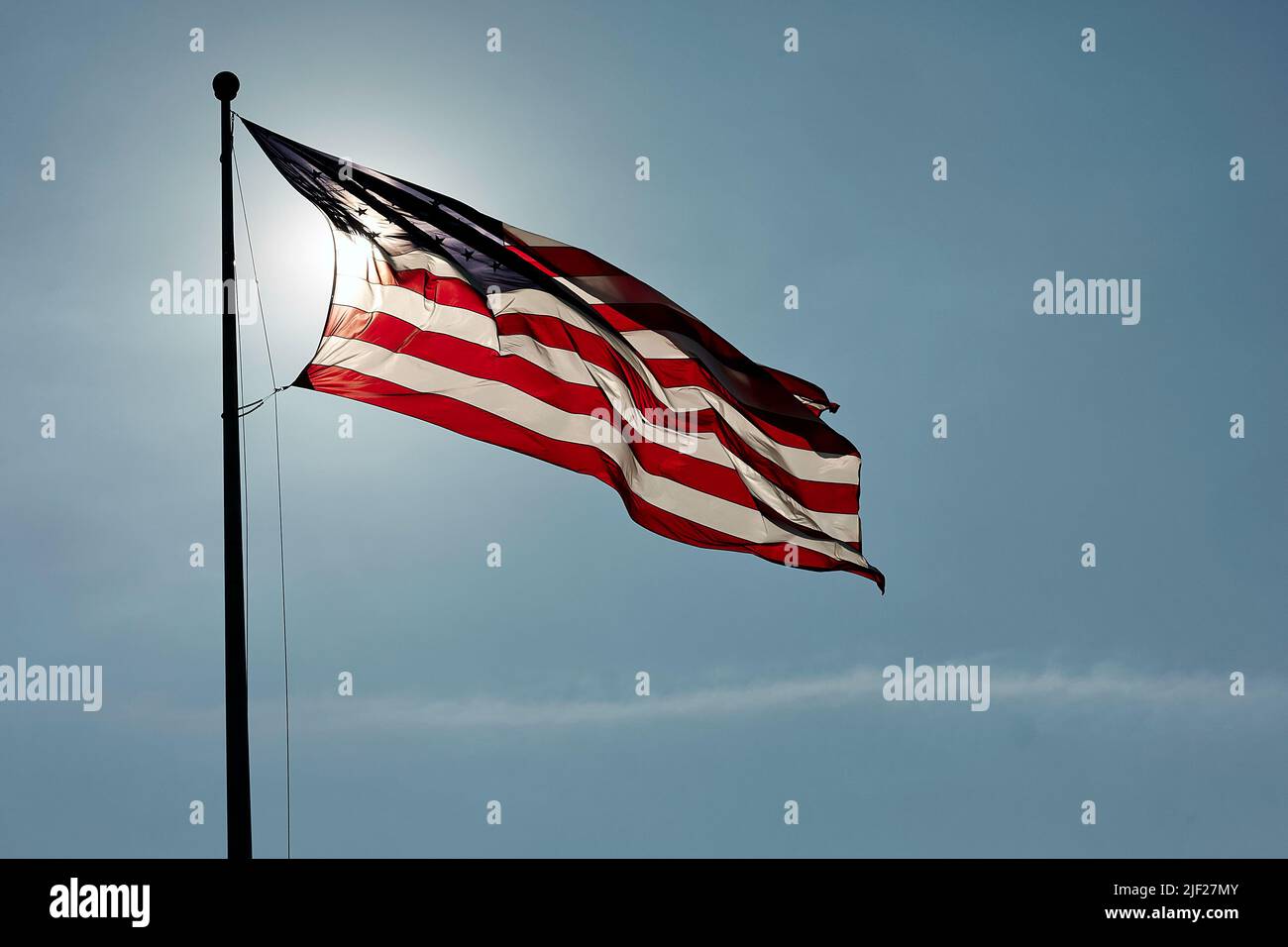 The flag of the United States , backlit by sunlight, and with a strong breeze. Stock Photo
