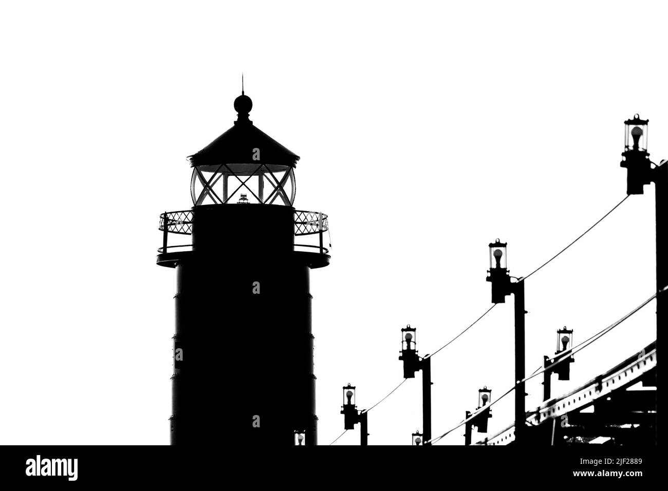 The lighthouse and catwalk in Grand Haven. Michigan, are shown in a black and white silhouette  Stock Photo
