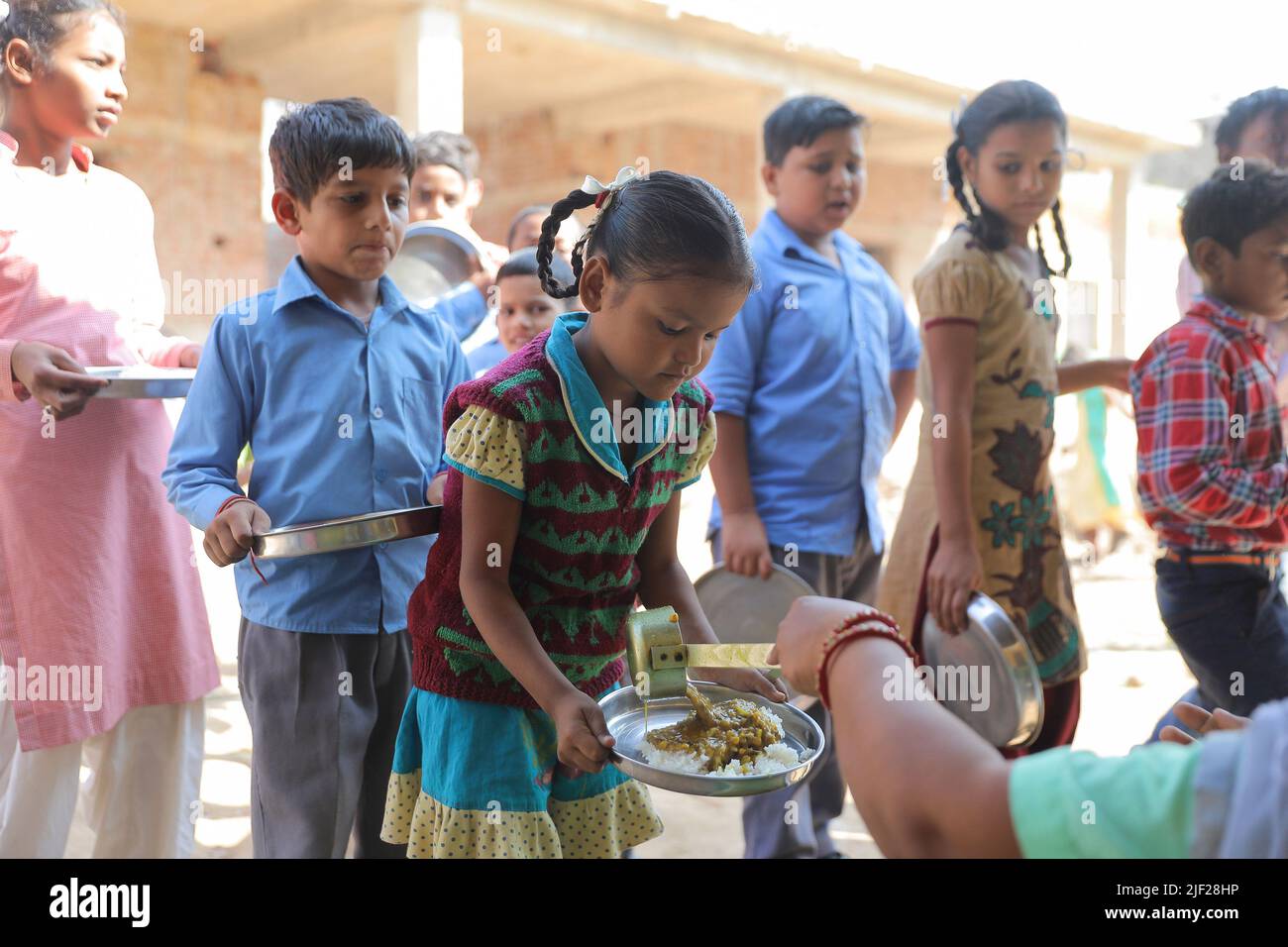 Children receive food served as part of The 'Mid Day Meal' scheme at A government school in rural area of Himachal Pradesh. Children engage in class activities at a government school in Baddi, a rural area in Himachal Pradesh. Stock Photo