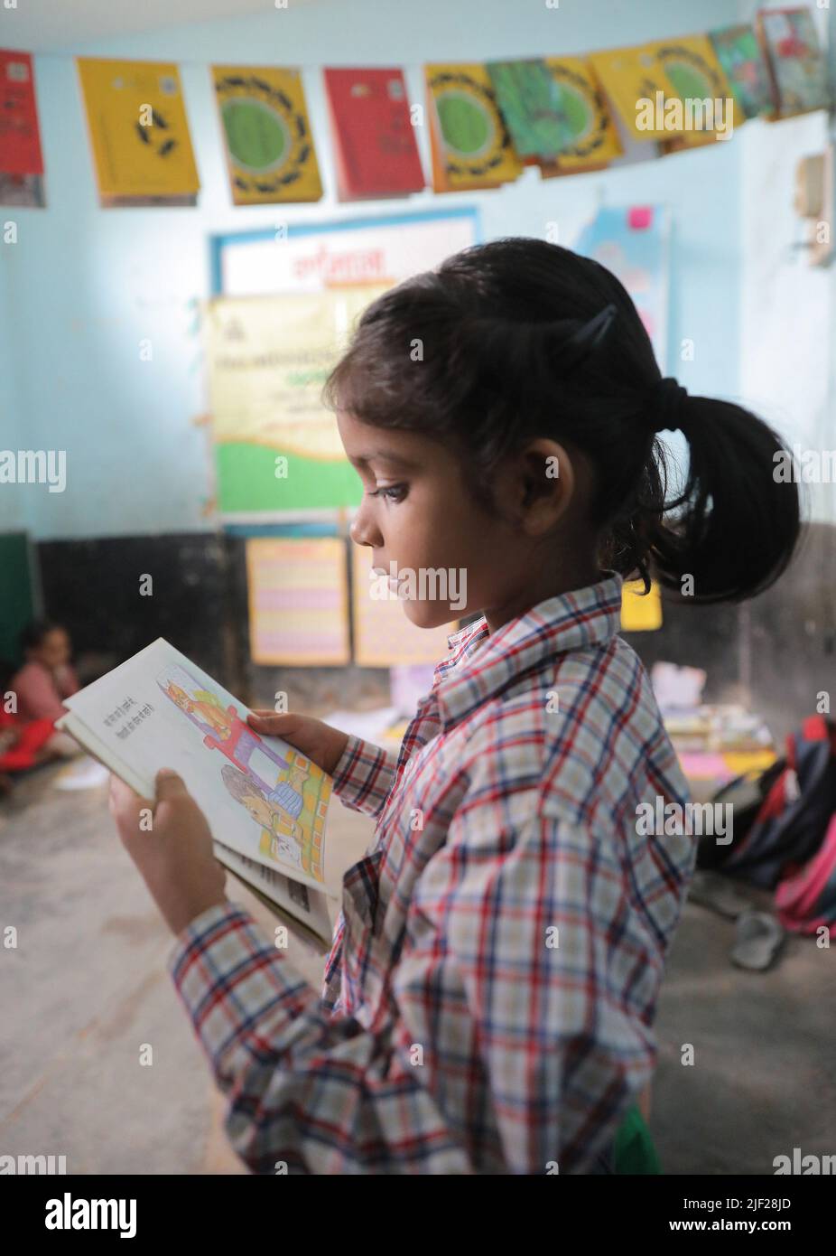 A child recites from a notebook during class at government school in rural area of Himachal Pradesh. Children engage in class activities at a government school in Baddi, a rural area in Himachal Pradesh. Stock Photo